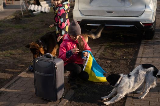 Ukraine military migration. two little girls with a suitcase. Flag of Ukraine, help. Crisis, military conflict.