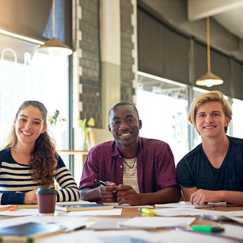 Portrait of a group of happy students having a study session in a cafe.