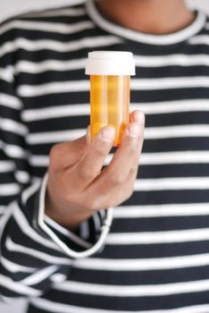 young man hand holding medicine pill container .