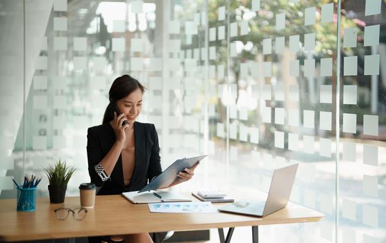 Young accountant marketing call consultants and using laptop computer to analyze sales growth in the global workplace market. accounting concept.