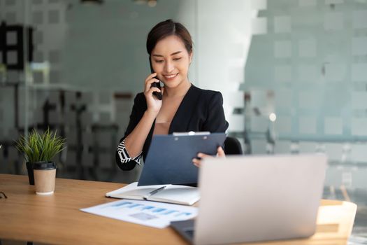 Young accountant marketing call consultants and using laptop computer to analyze sales growth in the global workplace market. accounting concept.