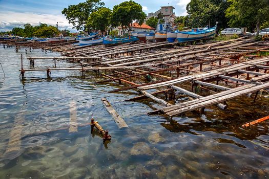 Boat docks on the slope rocky shores of a Black Sea bay of water with some improvised railing system and winches to hold them.