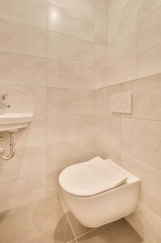 The bathroom is surrounded by marble tiles with a sink and toilet in the modern house