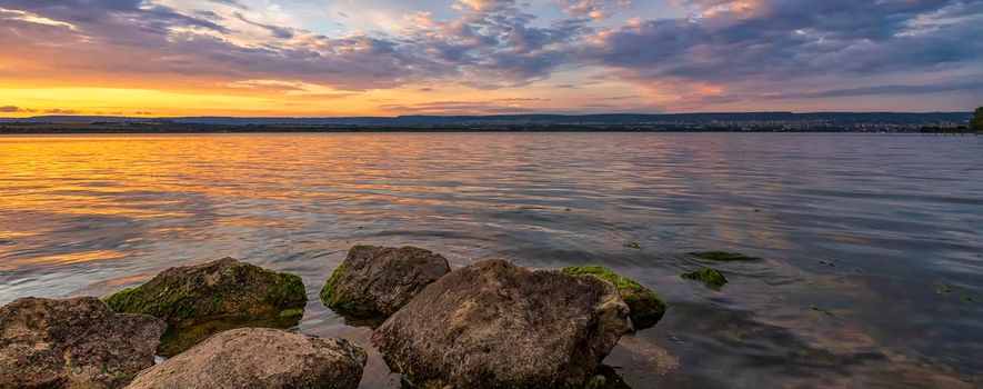 An incredible feeling at the beach of the calm sea after colorful sunrise or sunset