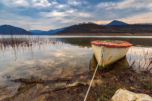 The idyllic mood on a  lakeshore with a wooden boat