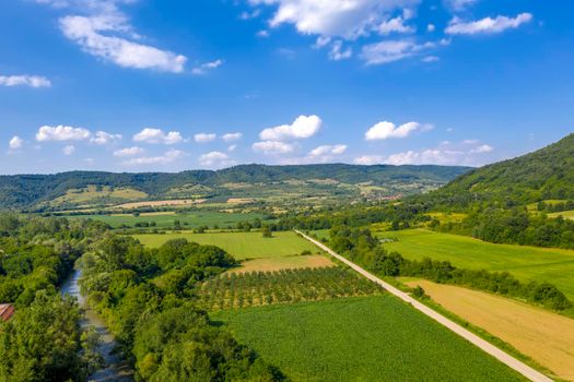 Aerial view from drone of the vast green landscape with river and hills