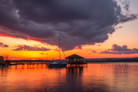 Beautiful sunset view at wooden jetty and boat.