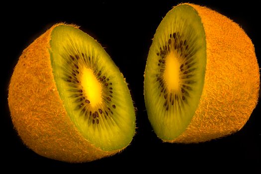 Kiwi fruit cut into halves shot against a black background.
