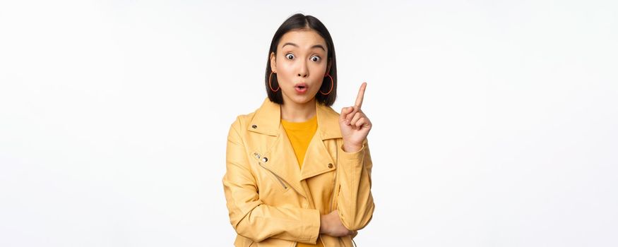 Idea. Enthusiastic asian girl has suggestion, raising finger up, eureka gesture, got excellent plan or solution, standing over white background.