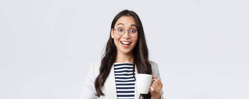 Business, finance and employment, female successful entrepreneurs concept. Close-up of outgoing smiling asian office worker talking to coworker at office kitchen, drinking coffee.