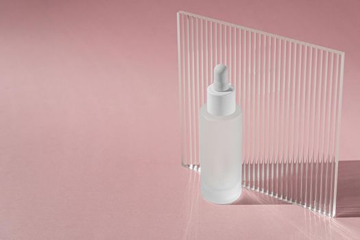 Hyaluronic acid oil, serum with collagen and peptides skin care product on background with acrylic ribbed plate. Cosmetic liquid mockup in transparent bottle. Mock up packaging, cosmetics design .