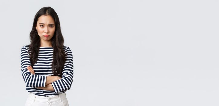 Lifestyle, people emotions and casual concept. Mad and offended cute silly asian girlfriend pouting, looking upset with hands crossed over chest, waiting for apology.