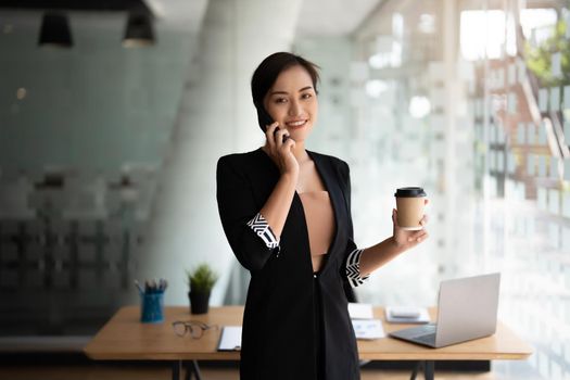 Portrait business asian woman standing while talking with mobile phone