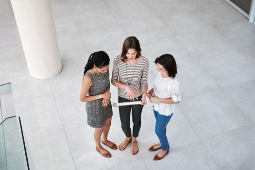 High angle shot of businesswomen talking in the lobby of their office.