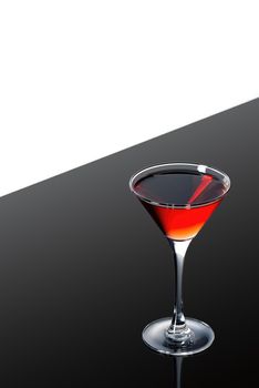 red martini cocktail on a dark background fading in to black without garnishe