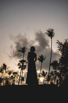 woman standing enjoy romantic sunrise moment, tropical garden.