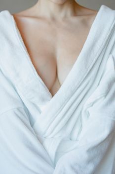 Woman in bathrobe, close up on chest.