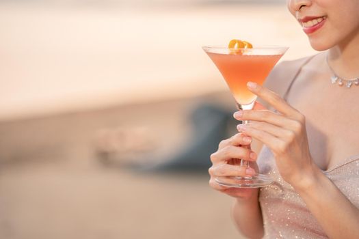 Woman drinking cocktails on the beach, romantic sunset moment. summer vacation.