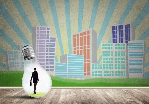 Businesswoman inside light bulb against city drawn concept