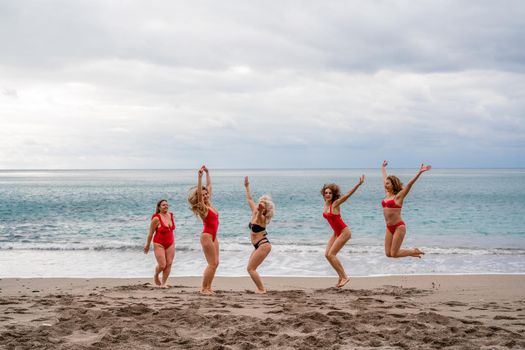 Big happy family or group of five friends is having fun against sunset beach. Beach holidays concept