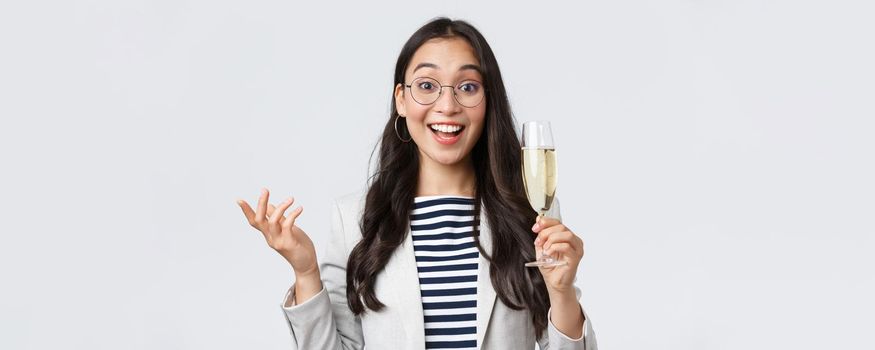 Business, finance and employment, female successful entrepreneurs concept. Enthusiastic happy businesswoman celebrating good deal, have office party with coworkers, make toast with glass champagne.