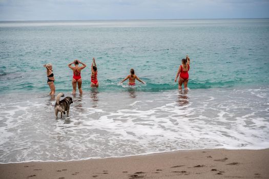 Big happy family or group of five friends is having fun against sunset beach. Beach holidays concept