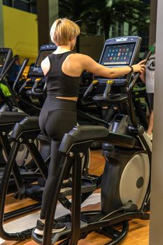 Elliptical trainer young woman health, from fitness workout from adult girl sportswear, active elliptical. Fitness club muscle, equipment