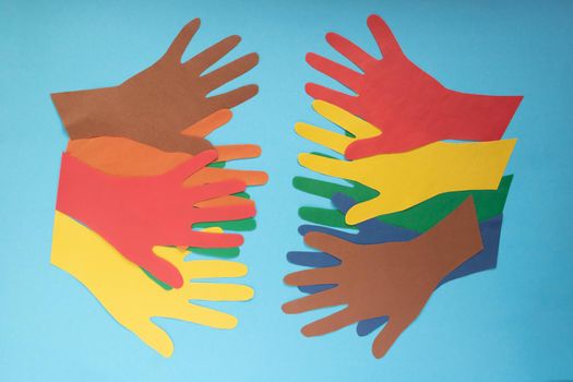 Abstract background open multicolored paper palms on a blue background.The concept of Autism Day and Youth Solidarity Day.