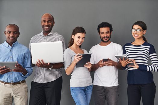 Studio shot of businesspeople using wireless technology against a gray background.