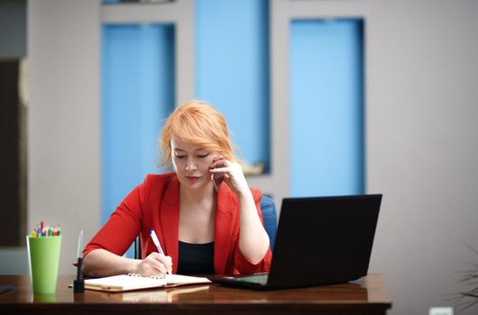 Redhead businesswoman have phone call at the office