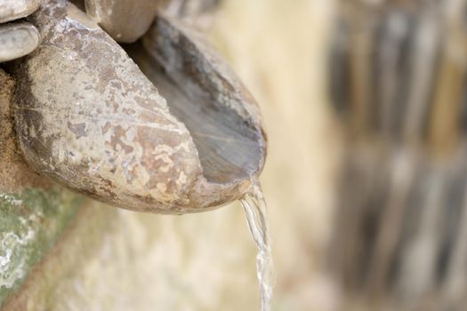 Jet of water flowing from stoneless mountain spring closeup. Landscape design concept