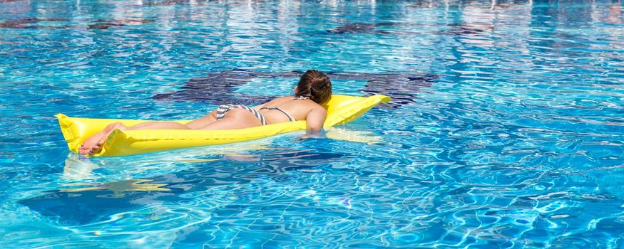 Young girl is relaxing on a air mattress