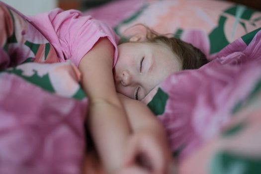 Little girl sleeping peacefully in pink bed at home. Work and rest schedule for children concept