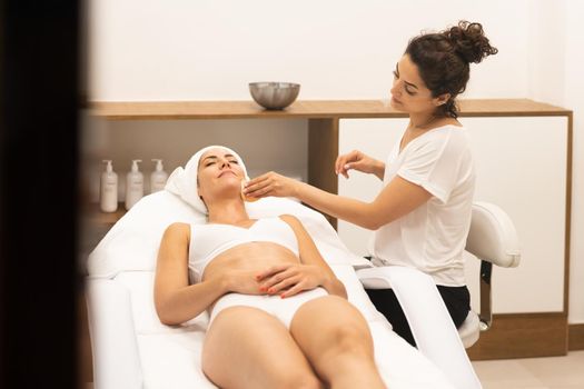 Aesthetics cleaning the skin to the face of a middle-aged woman in modern wellness center.. Beauty and Aesthetic concepts.