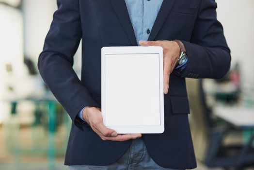Closeup shot of an unrecognizable businessman holding up a digital tablet with a blank screen in an office.