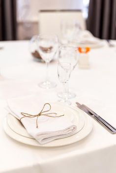 Plate, forks, napkin and knife in modern restaurant