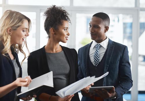 Shot of a group of businesspeople going through paperwork together in an office.