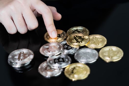 Close up of business woman holding some pieces of golden Bitcoin token , Bitcoin is one of the popular cryptocurrency