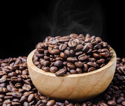 Cup fo black coffee in a wooden bowl on black background.