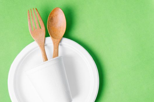 The Eco friendly biodegradable paper disposable for packaging food on green background.