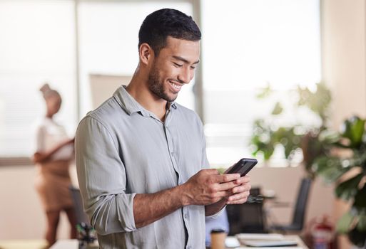 Shot of a young businessman using his smartphone to send a text message.