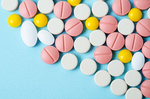 The Many colorful pills macro on blue background with copy space.
