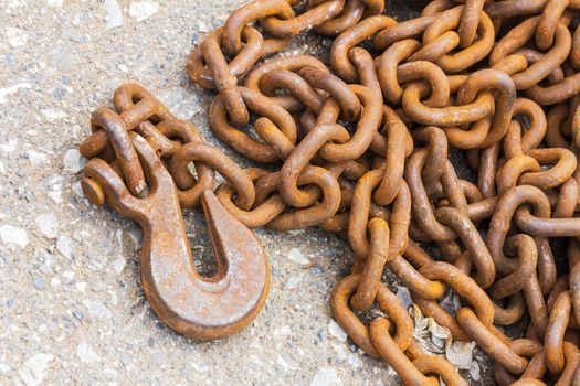 Close up Rusty hook and steel chain for industrial on floor