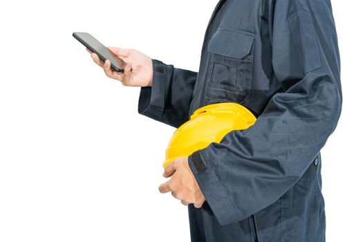 Cloes up Worker standing in blue coverall holding yellow hardhat and use smartphone isolated on white background