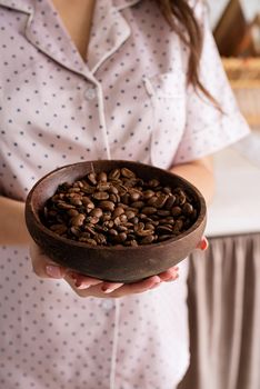 Alternative coffee brewing. young woman in lovely pajamas making coffee at home kitchen holding bowl with coffee beans