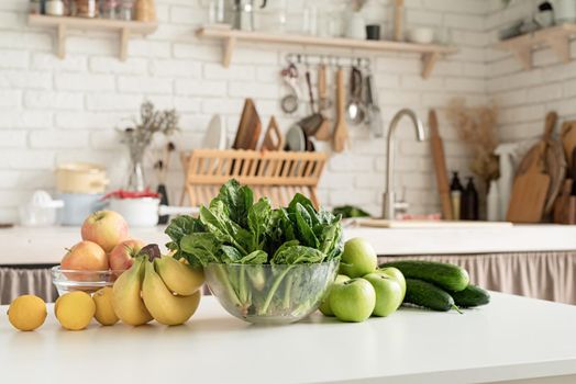 Preparing healthy foods. Healthy eating and dieting. Close up of table with green vegetables and fresh fruit in the kitchen