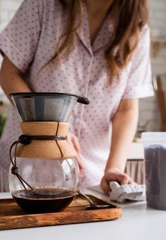 Alternative coffee brewing. young woman in lovely pajamas making coffee at home kitchen