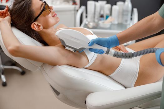 Armpit hair laser removal procedure with ipl machine in a beauty salon. Cosmetology