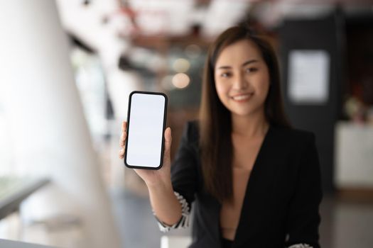 Mockup image of a beautiful business asian woman showing mobile phone with blank white screen.