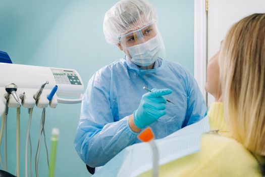 The patient treats her teeth at the dentist in the dental office . Dental fillings.